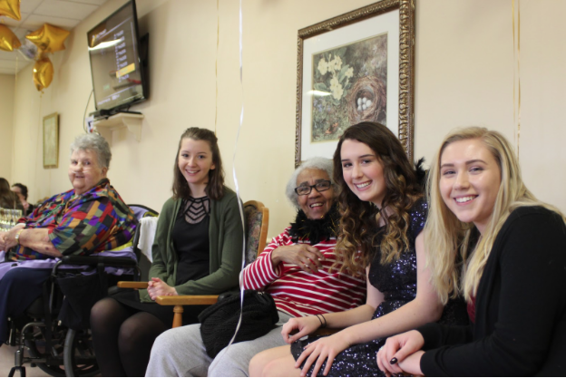(Left to right) Arlene Dams, Sydney Klonowski, Barbara Somerville, Cassidy Holderman, and Kassidy Quick gather for a picture after singing carols together at the event. Over 25 students volunteered for the event. Students helped decorate the Center with balloons and then mingled with the residents during the Prom.